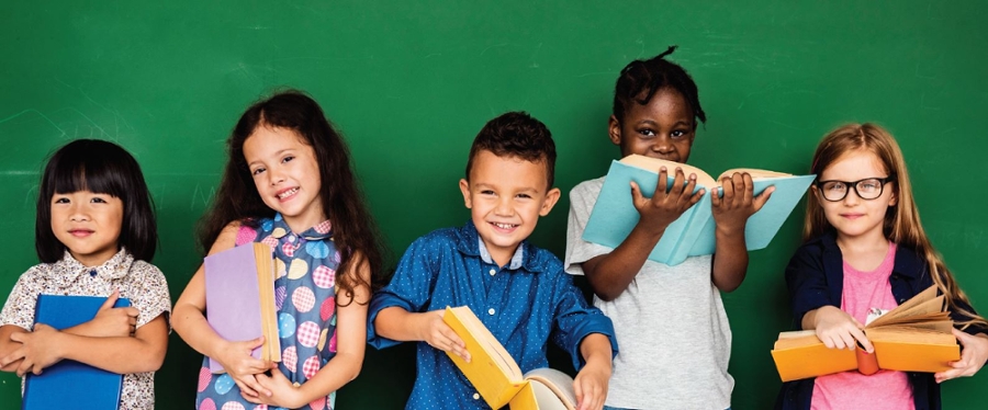 5 children's standing in front of a chalkboard