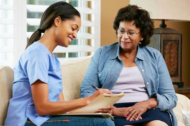 a woman showing another woman a folder of information