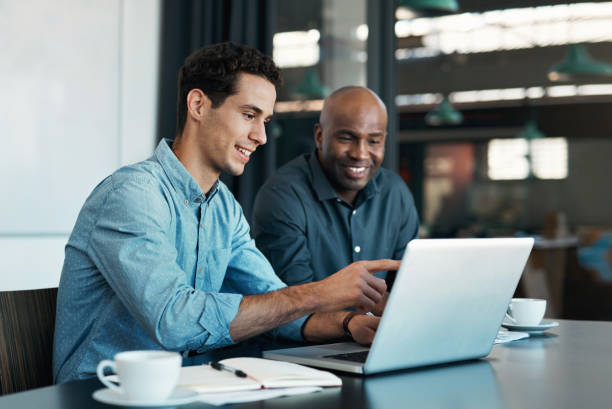 male showing another male something on the computer