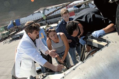 Group of maintenance workers inspect wing of plane