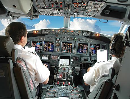 Two male pilots fly plane through clouds