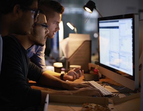 group of people working together at a computer 