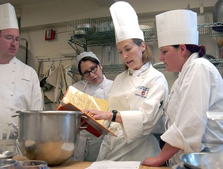 Culinary worker measures out baking powder on a scale