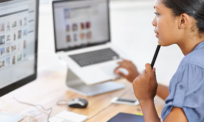 Female designer reviews photos on a computer monitor