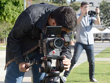 Man in denim shirt shoots footage outside