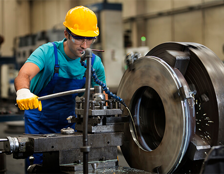 Male manufacturing worker works at machine