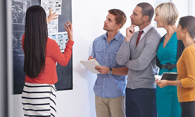 Woman in marketing explains cartoons to a group of people