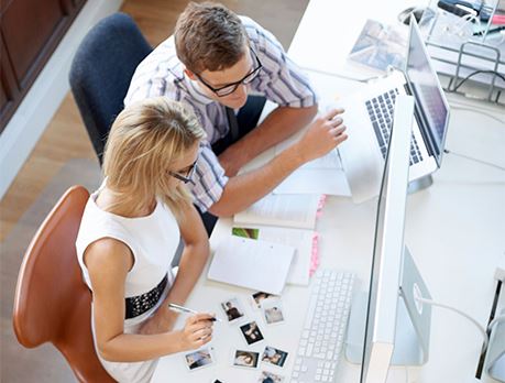 Man and woman working together in front of a computer