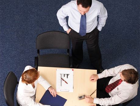 Group of business people sit around a table with laptops discussing marketing strategy