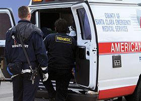 Two paramedics climb into back of ambulance