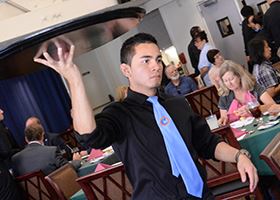 Waiter carries tray through busy dining room