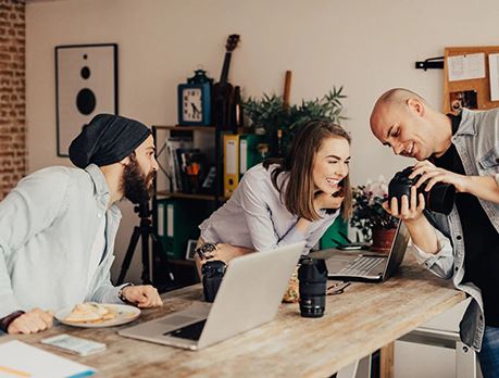 photographers looking at camera together at a desk