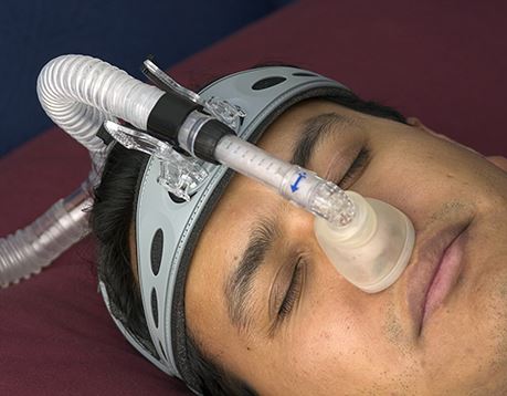 Male patient sleeps with sleep apnea mask