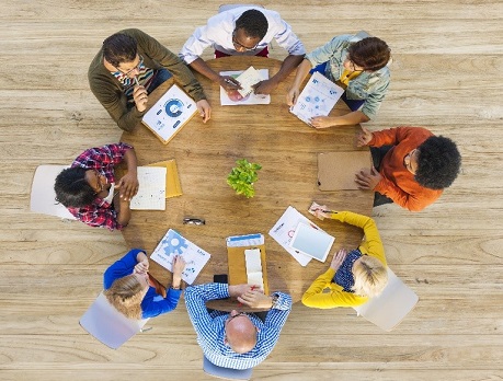 Group of people at a circular table discussing business