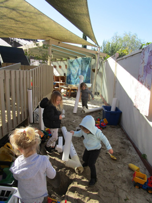 Children building a waterway in the sand.