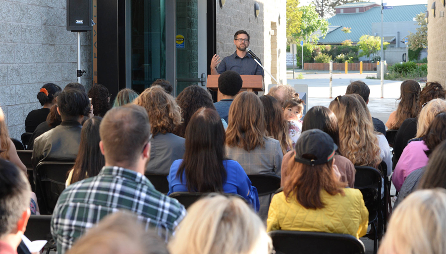 Professor Erik Rangno Talks to a Crowd of Event Attendees about the Coast Review Magazine