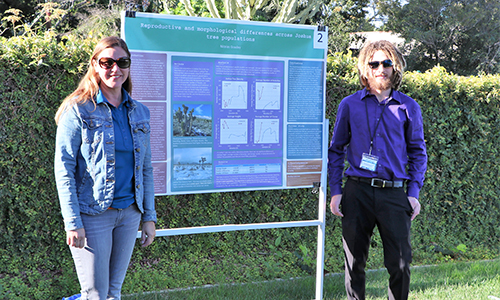 Mentor and student standing next to poster board