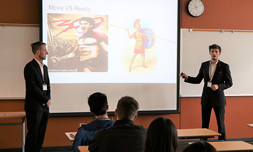 Two students presenting their research in front of a class