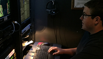 student in engineering room watching a monitor.