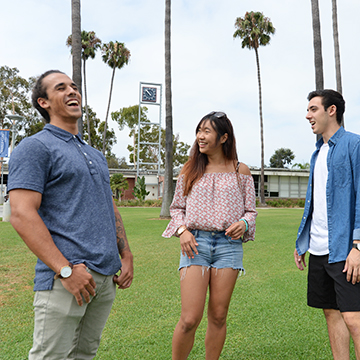 3 students talking at the main quad