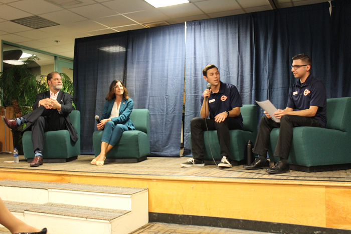 2 students on stage having a discussion with 2 other guest speakers