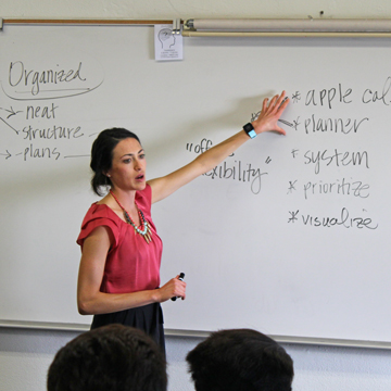 A club member speaking in front of a classroom