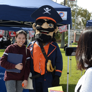 Student talking a picture with college mascot